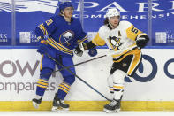 Buffalo Sabres forward Cody Eakin (20) and Pittsburgh Penguins forward Teddy Blueger (53) collide into the boards during the first period of an NHL hockey game, Sunday, April 18, 2021, in Buffalo, N.Y. (AP Photo/Jeffrey T. Barnes)