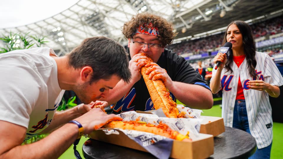 Two fans participate in an eating contest during the 2024 London Series. - Alex Bierens de Haan/MLB Photos/Getty Images