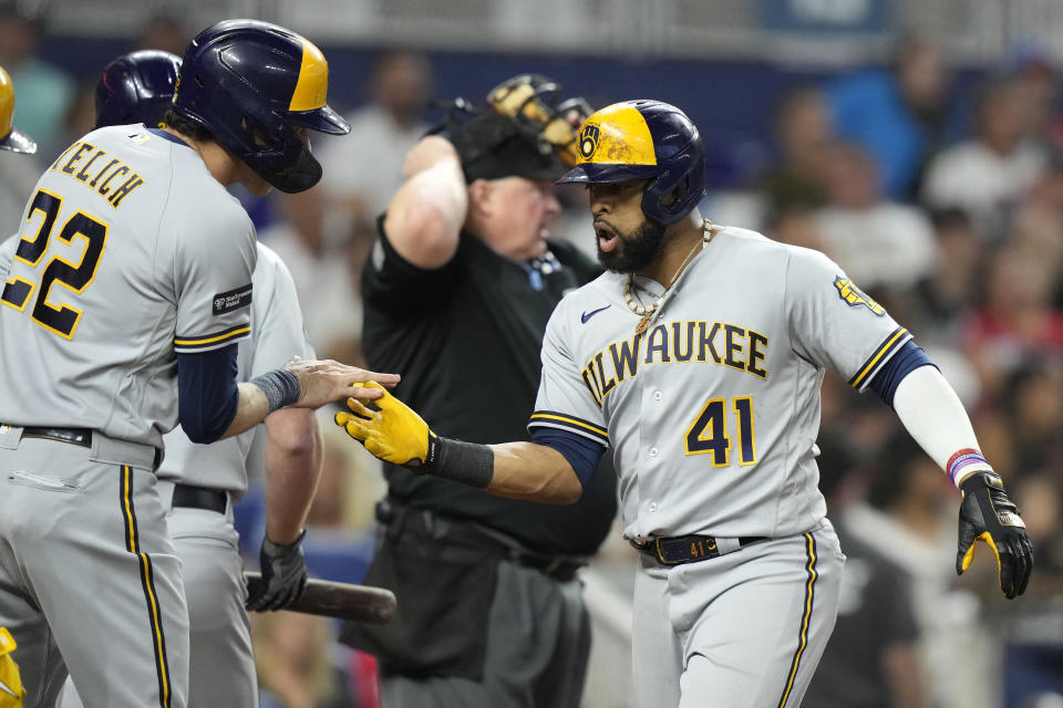 Milwaukee Brewers' Carlos Santana (41) shakes hands with Christian Yelich (22) after they scored on his three-run home run during the sixth inning of a baseball game against the Miami Marlins, Saturday, Sept. 23, 2023, in Miami. (AP Photo/Lynne Sladky)