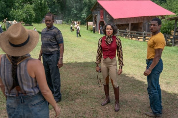 L–R: Uncle George (Courtney B. Vance), Leti and Tic (Jonathan Majors) mingle with the locals in Ardham.