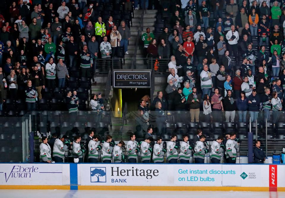 In this Jan. 9, 2018, photo, Seattle Thunderbirds hockey players join fans in standing during the singing of the national anthem at the ShoWare Center in Kent, Wash., about 20 miles south of Seattle. Hockey's history in Seattle dates back more than a century to when the Seattle Metropolitans hoisted the 1917 Stanley Cup.