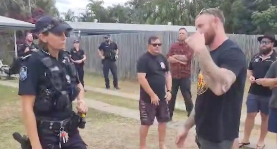 A photo of police talking with Rockhampton locals protesting Queensland's 'crime wave' by going to allegedly known young offenders houses.