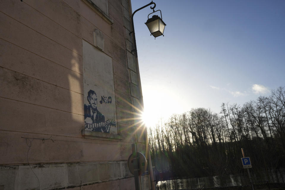 A mosaic by French artist Invader depicting jazz musician Django Reinhardt on a street of Samois-sur-Seine, south of Paris, Friday, March 1, 2024. For the Paris Olympics, it could almost have been a new sport: Score points by scouring France's capital for mosaics that a mystery artist who calls himself "Invader" has cemented to walls across the city, across the world and even had carried aloft to the International Space Station. (AP Photo/Thibault Camus)