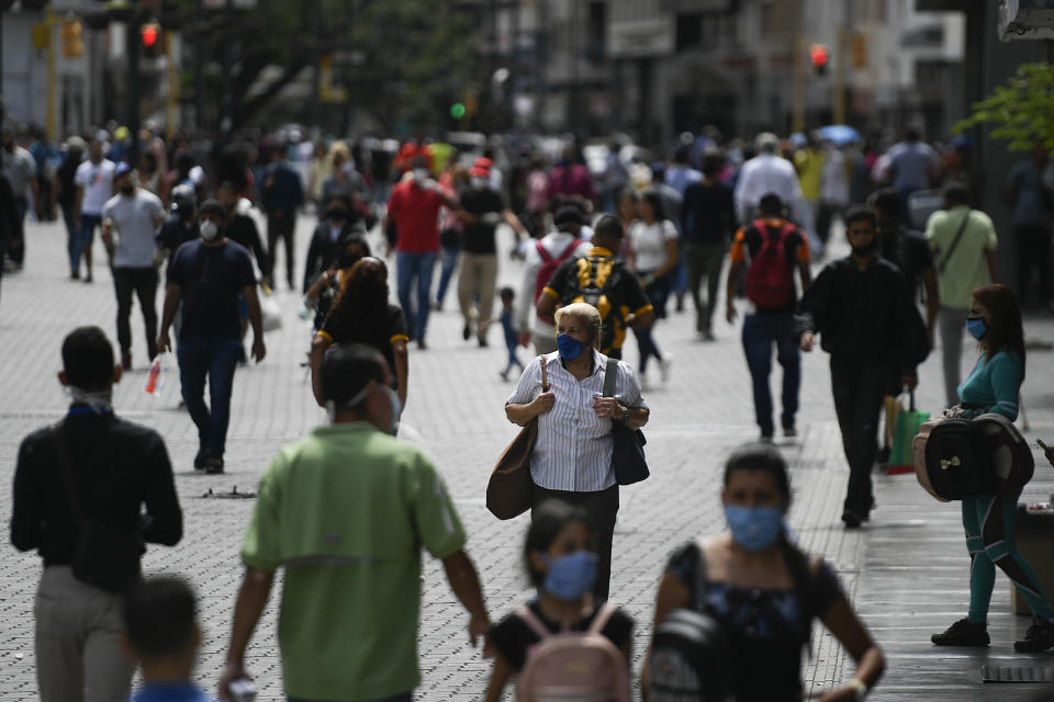 People wearing masks amid the new coronavirus pandemic walk on Sabana Grande boulevard in Caracas, Venezuela, Wednesday, June 17, 2020. (AP Photo/Matias Delacroix)