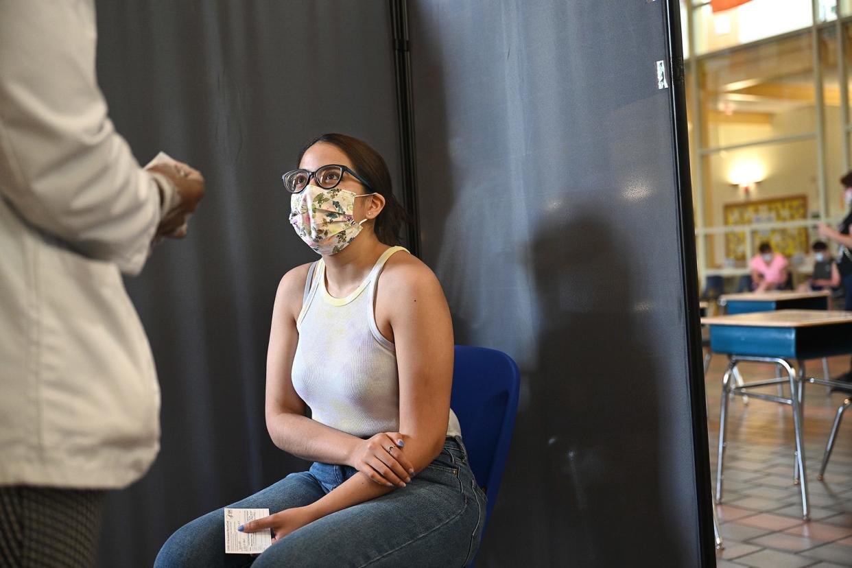 Tyffany Segura, 20, of Framingham talks to her medical technician before getting the COVID-19 vaccine during a clinic at the Woodrow Willson Elementary School in Framingham, May 22, 2021.