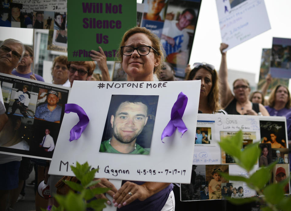 FILE - In this Friday, Aug. 17, 2018 file photo, Christine Gagnon of Southington, Conn. protests with other family and friends who have lost loved ones to OxyContin and opioid overdoses at Purdue Pharma LLP headquarters in Stamford, Conn. Gagnon lost her son Michael 13 months earlier. (AP Photo/Jessica Hill)