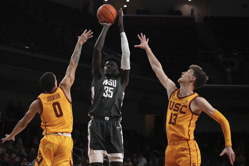 Washington State forward Mouhamed Gueye, center, shoots as Southern California forward Kobe Johnson, left, and guard Drew Peterson defend during the first half of an NCAA college basketball game Thursday, Feb. 2, 2023, in Los Angeles. (AP Photo/Mark J. Terrill)