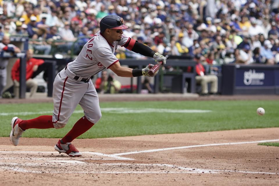 Washington Nationals' Cesar Hernandez bunts for an RBI single during the fourth inning of a baseball game against the Milwaukee Brewers Sunday, May 22, 2022, in Milwaukee. (AP Photo/Morry Gash)