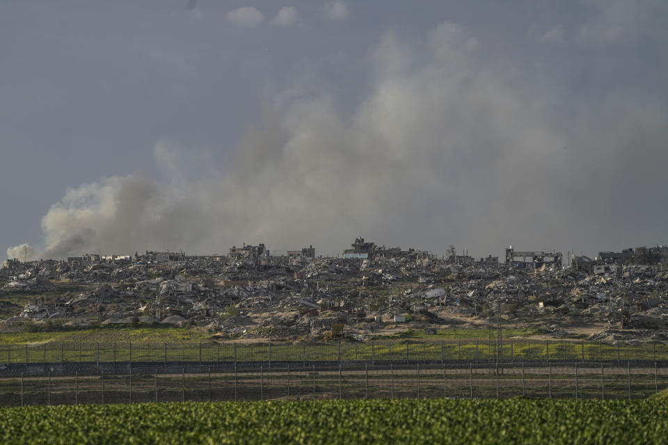 Smoke rises behind rubble from buildings destroyed in the Israeli Army's ground operation in the Gaza Strip as seen from southern Israel, adjacent to the Gaza border fence, Thursday, Feb. 1, 2024. (AP Photo/Tsafrir Abayov)