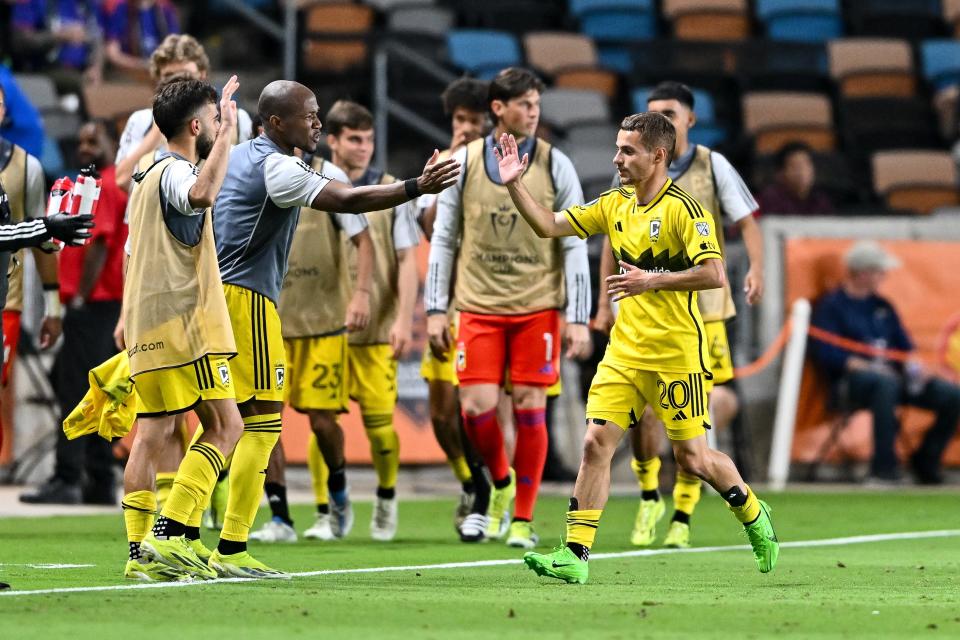 Crew midfielder Alexandru Matan high fives teammates after scoring the winning goal against Houston on Wednesday.