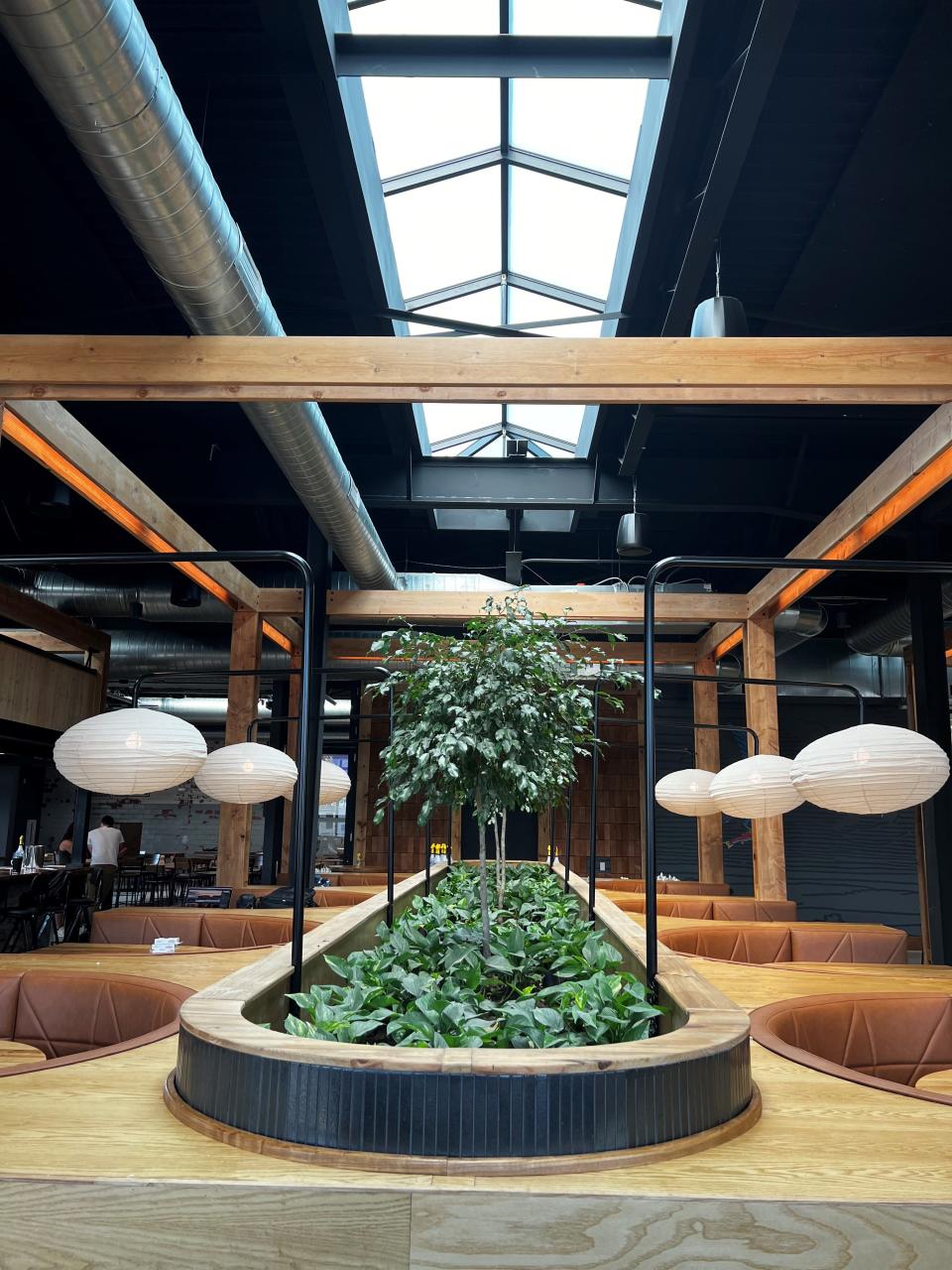 Greenery separates booths with lantern lights inside Big Grove Brewery in Des Moines.