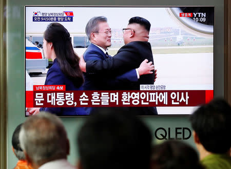 People watch the televised broadcast in Seoul, South Korea, September 18, 2018, of South Korea's President Moon Jae-in as he is greeted by North Korea's leader Kim Jong Un after arriving in Pyongyang for the inter-Korean summit. REUTERS/Kim Hong-Ji