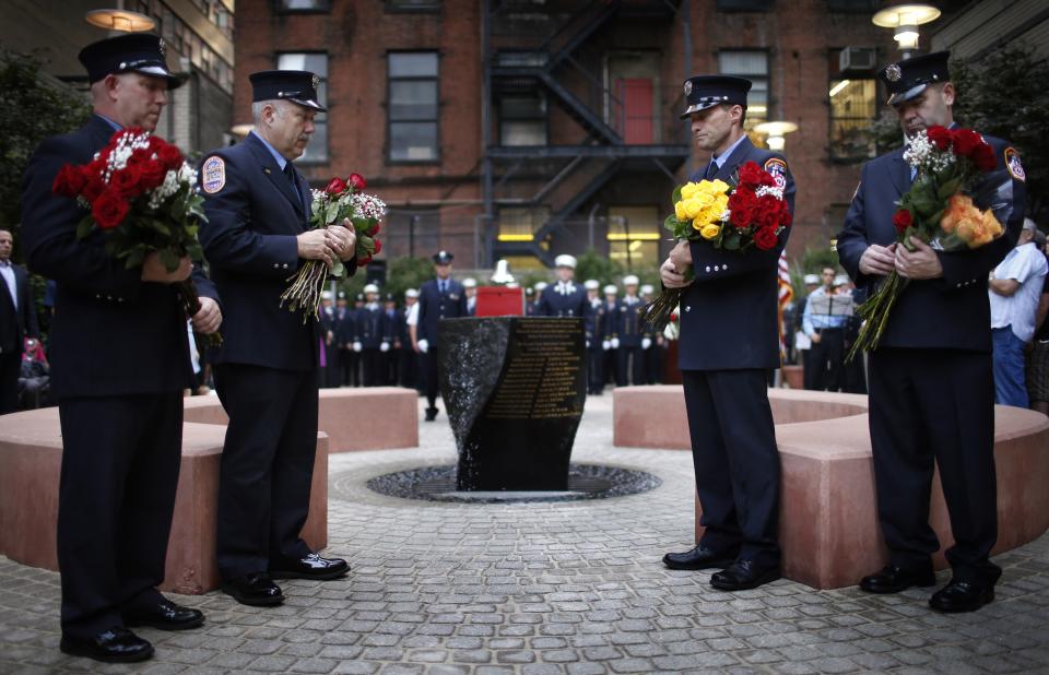 New York City firefighters from Engine 54, Ladder 4, Battalion 9, hold flowers during a ceremony at a park dedicated to honoring members of the firehouse on West 48th Street who lost their lives in the September 11, 2001 attacks on the World Trade Center on the 12th anniversary of the attacks in New York, September 11, 2013. 15 fire fighters from Engine 54, Ladder 4, Battalion 9 died in the 9/11 attacks, the most of any fire company in New York. (REUTERS/Mike Segar)