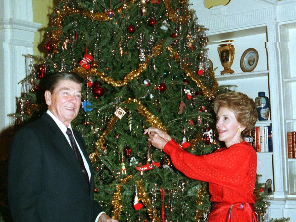 President Ronald Reagan and Nancy Reagan decorate a Christmas tree at the White House.