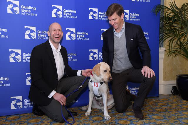 <p>Gary Gershoff/Getty Images</p> Thomas Panek, Ten and Eli Manning