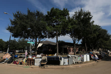 FILE PHOTO: The contents of a flooded home are moved to the street in the aftermath of tropical storm Harvey in Katy, Texas, U.S., September 8, 2017. REUTERS/Mike Blake/File Photo