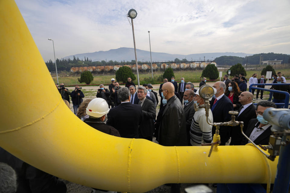 Lebanese Energy Minister Walid Fayad, center left, tours the Biddawi oil facility in the northern city of Tripoli, Lebanon, Tuesday, Dec. 28, 2021. Fayad launched two projects in the country’s north on Tuesday to facilitate the flow of natural gas from Egypt. The move aims to improve electricity production and expand the country’s tanks to increase oil reserves. (AP Photo/Hassan Ammar)