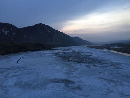 The frozen Tumen river separating North Korea (L) from China is seen in this photo taken from the Chinese border city of Tumen, China, March 18, 2015. REUTERS/Staff