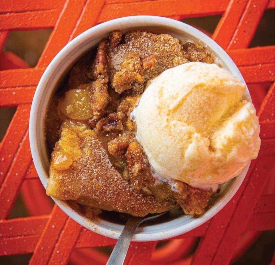 Peach cobbler menu item topped with ice cream at the Peach Cobbler Factory.