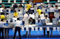 Election officers count votes at a ballot counting centre for Japan's upper house election in Tokyo