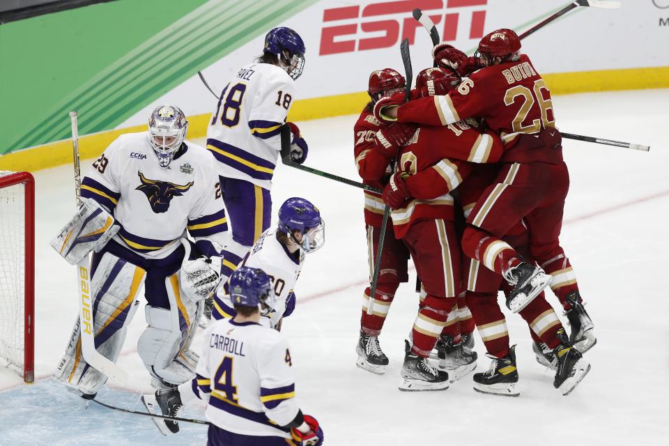 Denver's Shai Buium (26) and teammates celebrate a goal by Ryan Barrow against Minnesota State's Dryden McKay (29) during the third period of the NCAA men's Frozen Four championship college hockey game Saturday, April 9, 2022, in Boston. (AP Photo/Michael Dwyer)