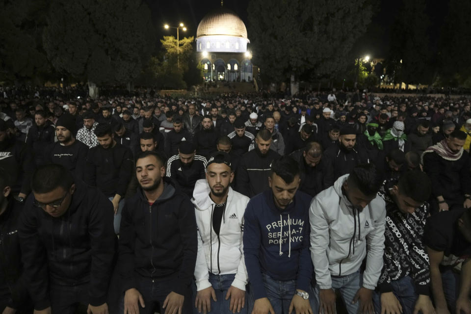 Palestinians gather for early morning prayer during the Muslim holy month of Ramadan, shortly before Israeli police clashed with protesters at the Al Aqsa Mosque compound, in Jerusalem's Old City, Friday, April 22, 2022. Israeli police and Palestinian youths clashed again at the major Jerusalem holy site sacred to Jews and Muslims on Friday despite a temporary halt to Jewish visits to the site, which are seen as a provocation by the Palestinians. (AP Photo/Mahmoud Illean)