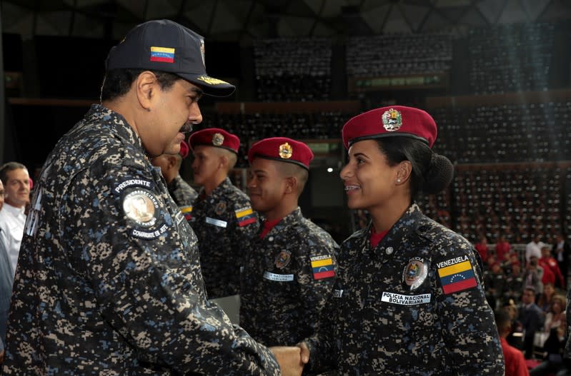 FILE PHOTO: Venezuela's President Nicolas Maduro shakes hands with a newly graduated police woman during a Bolivarian National Police officers' graduation ceremony in Caracas