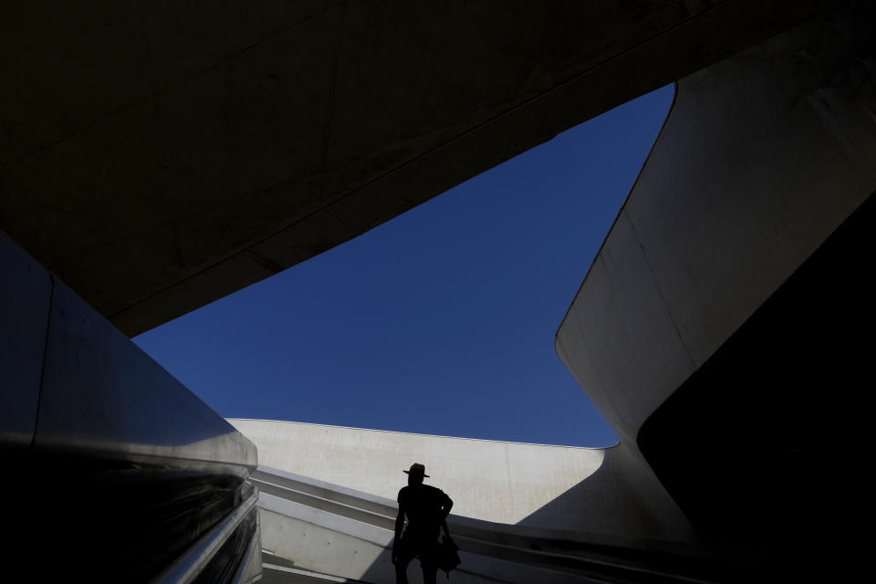 A man wears a hat as he climbs the stairs at Eleftheria Square in downtown Nicosia, Cyprus, Thursday, July 13, 2023. The Meteorological Department said the heatwave's highest temperatures are expected July 14-15 when they're expected to reach 42-43 degrees Celsius inland and 34-36 degrees in the island's main Troodos mountain range. (AP Photo/Petros Karadjias)