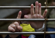 A supporter gestures, signifying the "Five demands - not one less", outside a court in Hong Kong, Thursday, March 4, 2021. A marathon court hearing for 47 pro-democracy activists in Hong Kong charged with conspiracy to commit subversion enters its fourth day on Thursday, as the court deliberates over whether the defendants will be granted bail. (AP Photo/Vincent Yu)