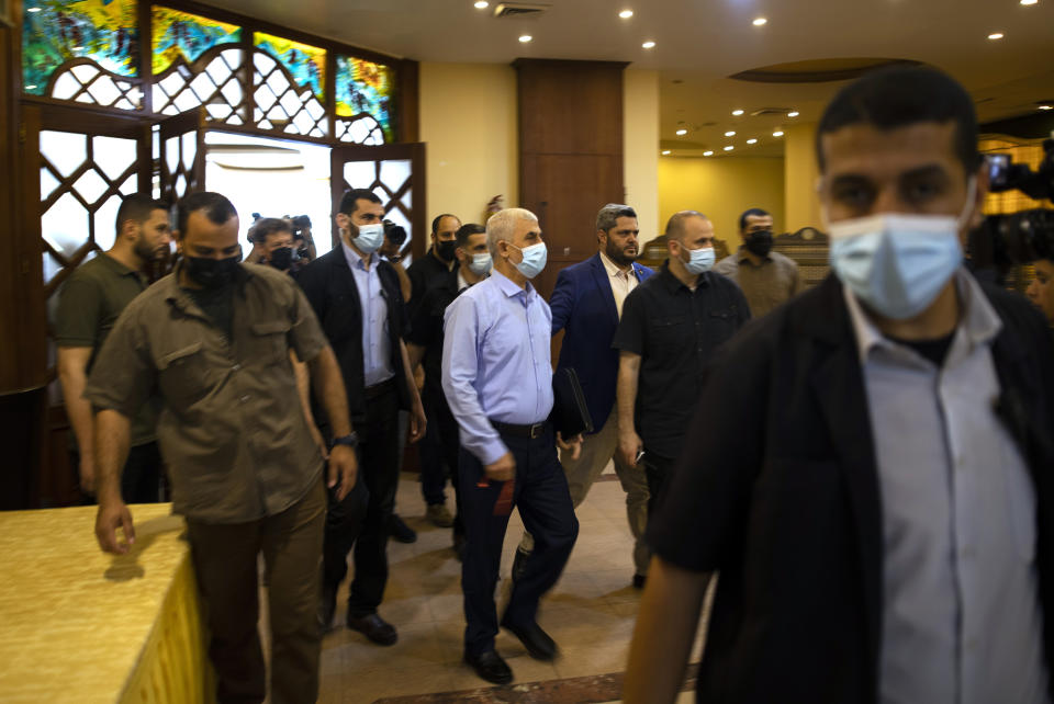 Yahya Sinwar, the Palestinian leader of Hamas in the Gaza Strip, is surrounded by guards as he arrives for a meeting with foreign press, in Gaza City, Wednesday, May 26, 2021. (AP Photo/Khalil Hamra)