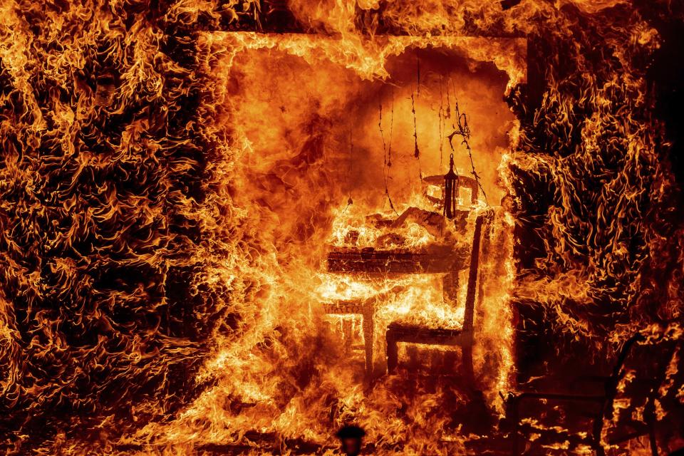 Flames engulf a chair inside a burning home as the Oak Fire rages in Mariposa County, Calif., on July 23, 2022. (AP Photo/Noah Berger)