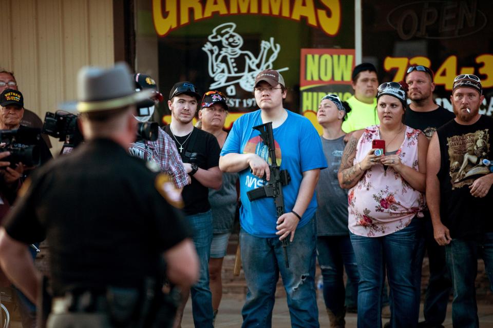 Counterprotesters watch a Black Lives Matter march as curfew approaches June 15 in Bethel, Ohio. Protesters took to the streets after the death of George Floyd, a Black man who died May 25 in Minneapolis after a white police officer kneeled on his neck, ignoring Floyd's pleas that he could not breathe.