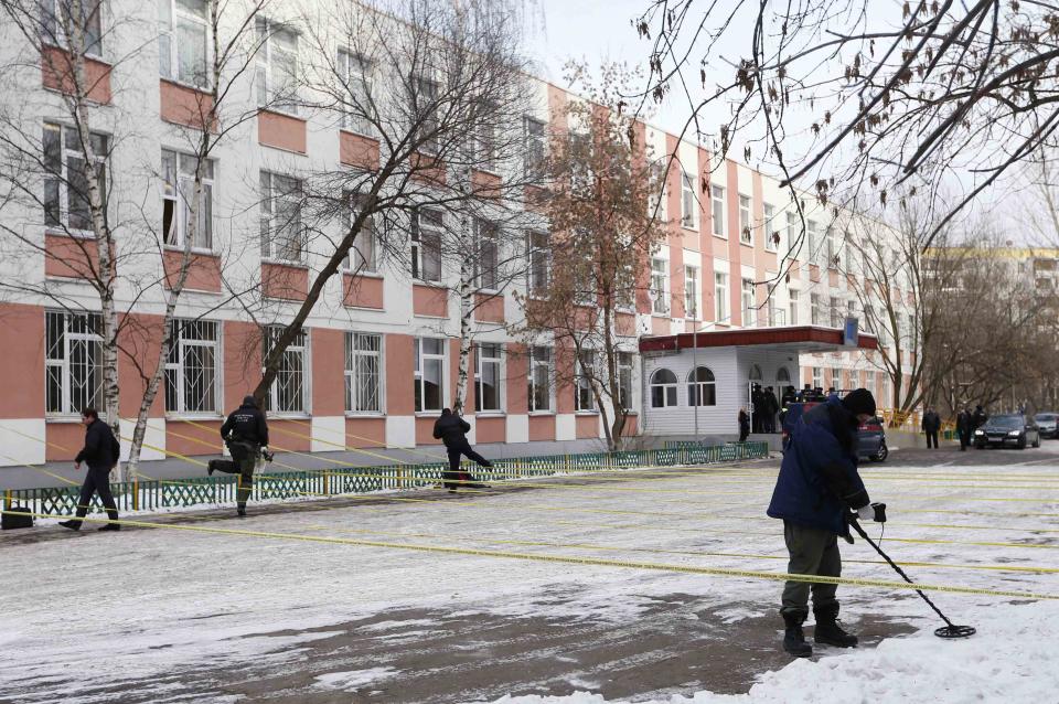 A security service member uses a mine and metal detector as he works near the building of a high school, where a shooting incident has occurred, on the outskirts of Moscow, February 3, 2014. A Moscow high-school student shot a teacher and a police officer dead and held more than 20 other students hostage in a classroom on Monday before he was disarmed and detained, police said, just days before Russia hosts the Winter Olympics. REUTERS/Maxim Shemetov (RUSSIA - Tags: CRIME LAW EDUCATION)