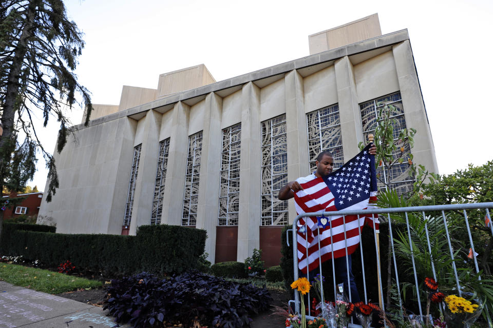 FILE—A man places an American flag outside the Tree of Life synagogue in Pittsburgh on Sunday, Oct. 27, 2019, the first anniversary of the shooting at the synagogue, that killed 11 worshippers. (AP Photo/Gene J. Puskar, File)