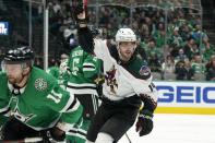 Arizona Coyotes defenseman Shayne Gostisbehere (14) celebrates after scoring as Dallas Stars center Luke Glendening (11) skates past in the second period of an NHL hockey game in Dallas, Monday, Dec. 6, 2021. (AP Photo/Tony Gutierrez)