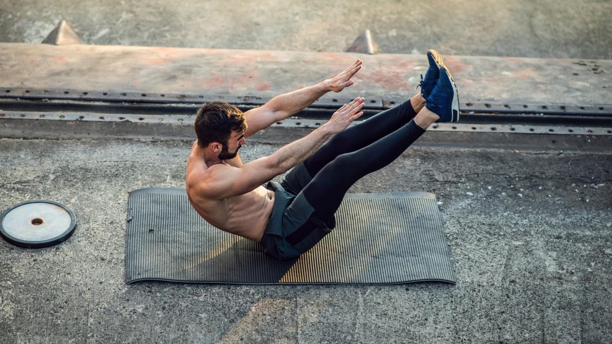  a photo of a man doing a jack knife sit up 