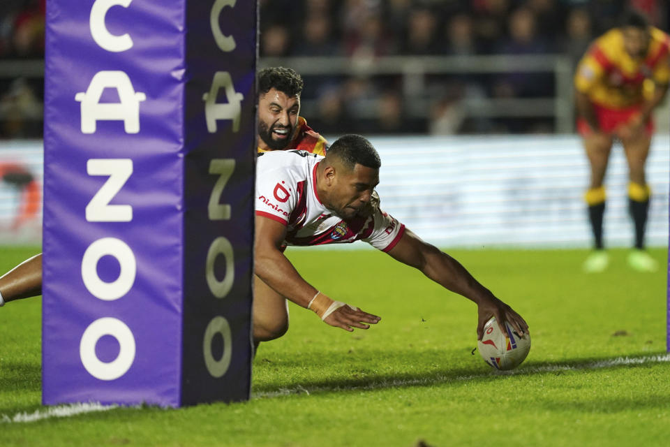 Tonga's Moeaki Fotuaika scores a try, during the Rugby League World Cup group D match between Tonga and Papua New Guinea at Totally Wicked Stadium, in St Helens, Merseyside, England, Tuesday, Oct. 18, 2022. (Martin Rickett/PA via AP)