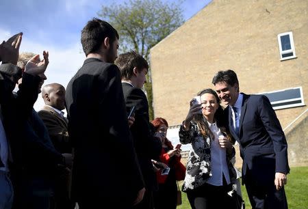 Britain's opposition Labour Party leader Ed Miliband (R) poses for a "selfie" with a supporter before the launch of their Manifesto for Young People at Bishop Grosseteste University in Lincoln, central England April 17, 2015. REUTERS/Dylan Martinez