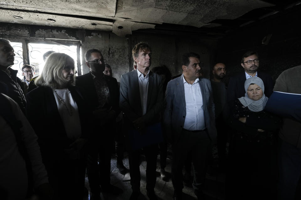 Sven Kuhn von Burgsdorff, the European Union representative for the Palestinian Territories, center, surveys the damage of a torched house in the West Bank town of Hawara which was set ablaze by radical Jewish settlers earlier this week, Friday, March 3, 2023. On Monday scores of Israeli settlers have gone on a violent rampage in the northern West Bank town of Hawara, setting cars and homes on fire after two settlers were killed by a Palestinian gunman. (AP Photo/Majdi Mohammed)