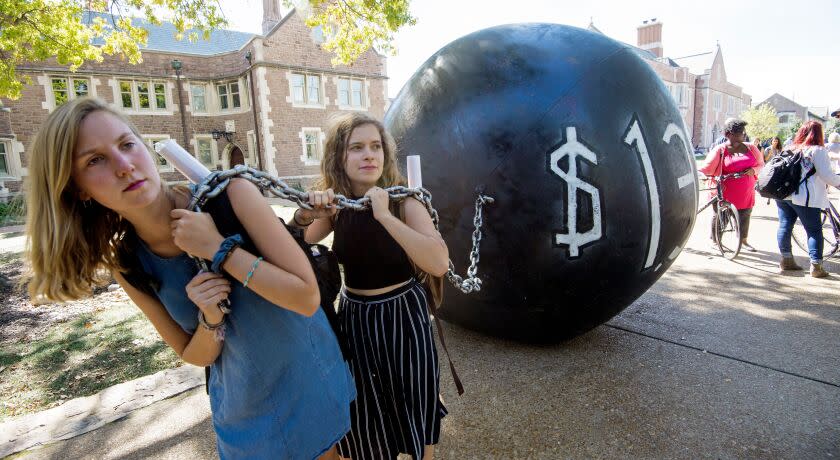 Students pull a mock "ball & chain" representing the $1.4 trilling outstanding student debt at Washington University in St. Louis, Missouri, where second presidential debate will be held between Republican nominee Donald Trump and his Democratic counterpart Hillary Clinton / AFP / PAUL J. RICHARDS (Photo credit should read PAUL J. RICHARDS/AFP/Getty Images) ** OUTS - ELSENT, FPG, CM - OUTS * NM, PH, VA if sourced by CT, LA or MoD **