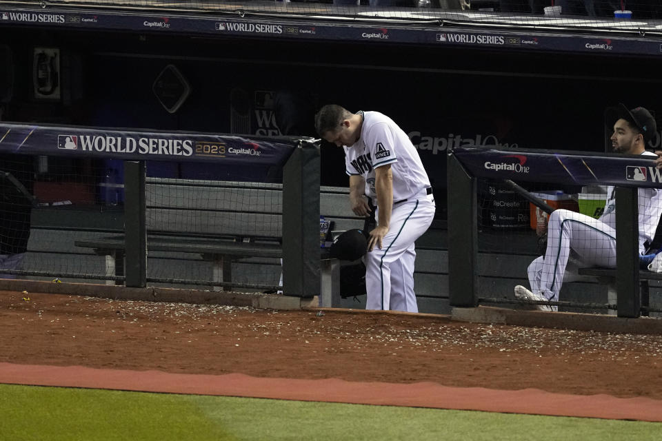 Arizona Diamondbacks relief pitcher Paul Sewald looks down as the Texas Rangers celebrate after winning Game 5 of the baseball World Series against the Arizona Diamondbacks Wednesday, Nov. 1, 2023, in Phoenix. The Rangers won 5-0 to win the series 4-1. (AP Photo/Ross D. Franklin)