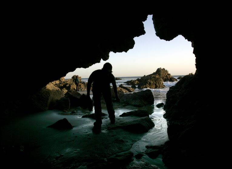 Greg Wood 25, of Northridge enters a cave on the beach at Leo Carillo State Park in Malibu which offers camping and beach access.