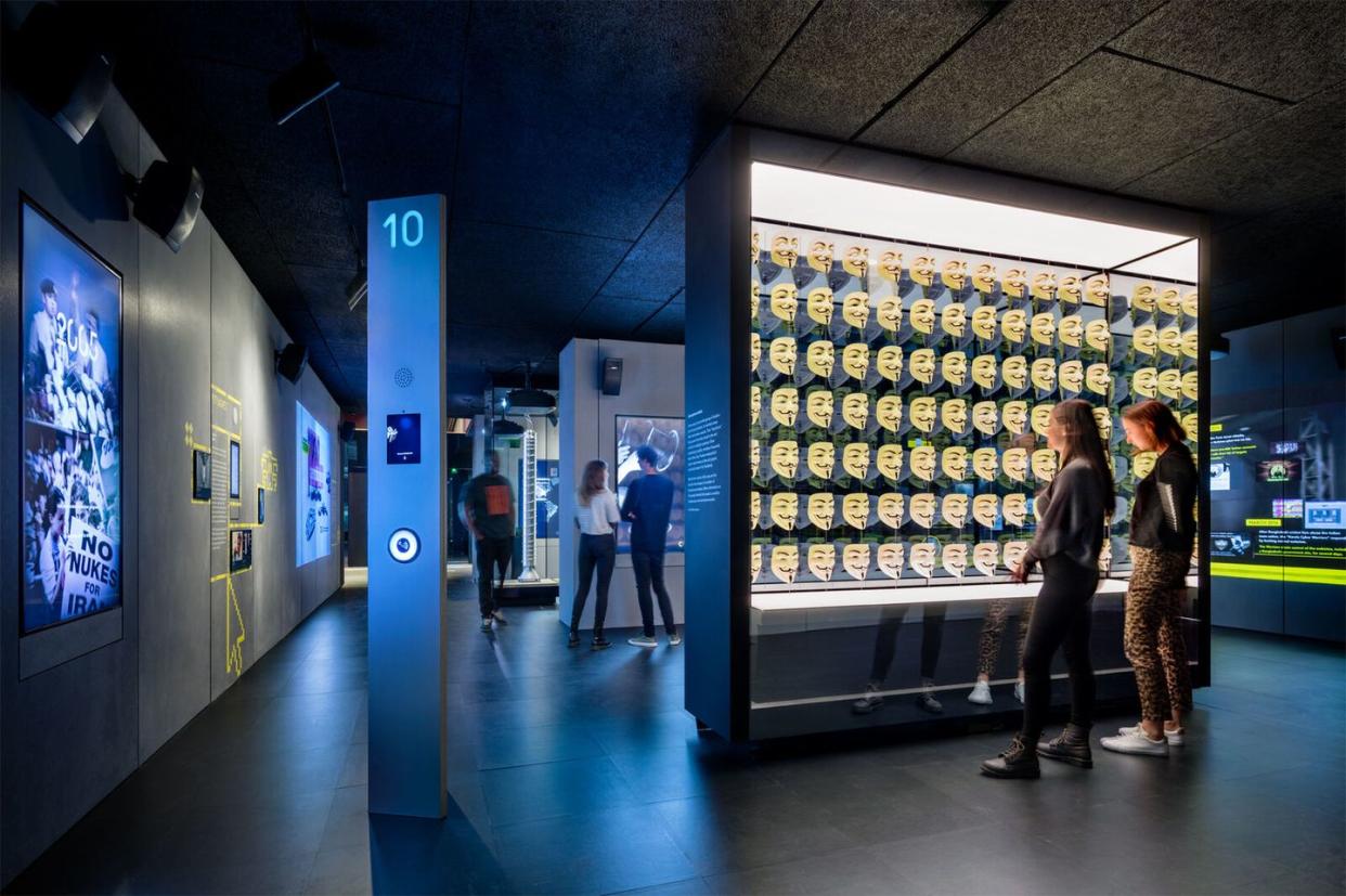 people standing in a room with large screens