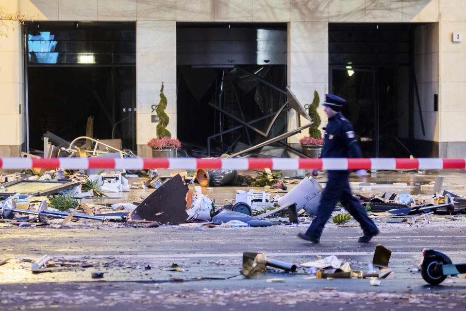 A police officer walks in front of debris after a huge aquarium burst at the Seal Life Aquarium in central Berlin, Germany, Friday, Dec. 16, 2022. (Christoph Soeder/dpa via AP)