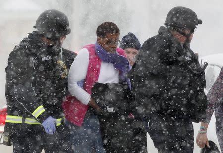 A woman is evacuated from a building where a shooter was suspected to be still holed up in Colorado Springs, Colorado, November 27, 2015, during a snowstorm. REUTERS/Rick Wilking