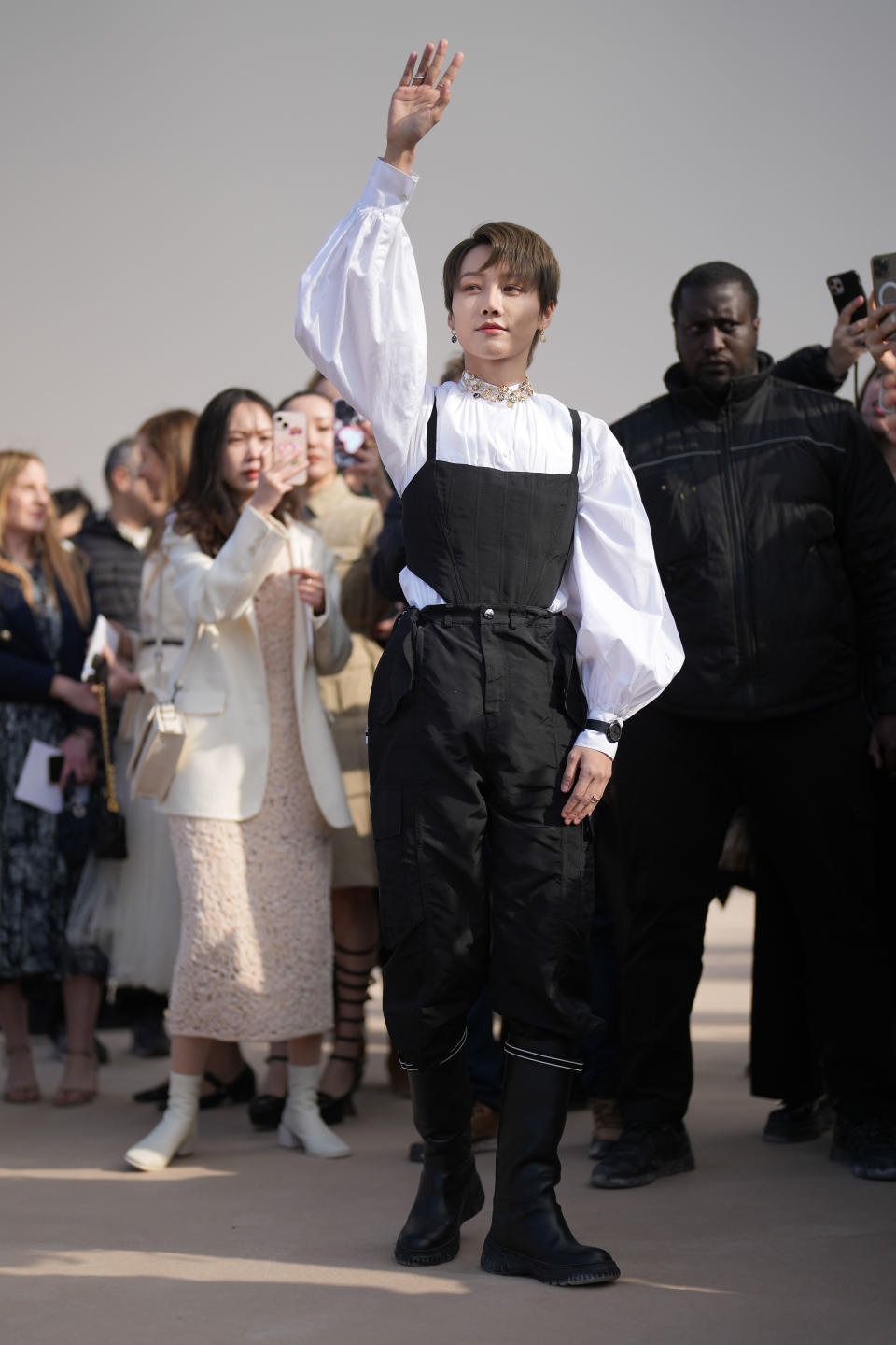 PARIS, FRANCE - FEBRUARY 28: Liu Yuxin wears gold earrings from Dior, a gold large pendant necklace from Dior, a white high neck / puffy sleeves shirt, a black corset tank-top from Dior, a black watch, black puffy pants, black shiny leather knees boots from Dior , outside Dior, during Paris Fashion Week - Womenswear Fall Winter 2023 2024, on February 28, 2023 in Paris, France. (Photo by Edward Berthelot/Getty Images)
