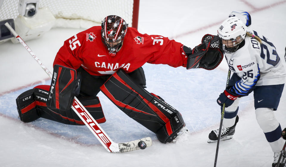 Canada goalie Ann-Renee Desbiens, left, blocks a shot from United States' Kendall Coyne Schofield during the third period of the IIHF hockey women's world championships title game in Calgary, Alberta, Tuesday, Aug. 31, 2021. (Jeff McIntosh/The Canadian Press via AP)