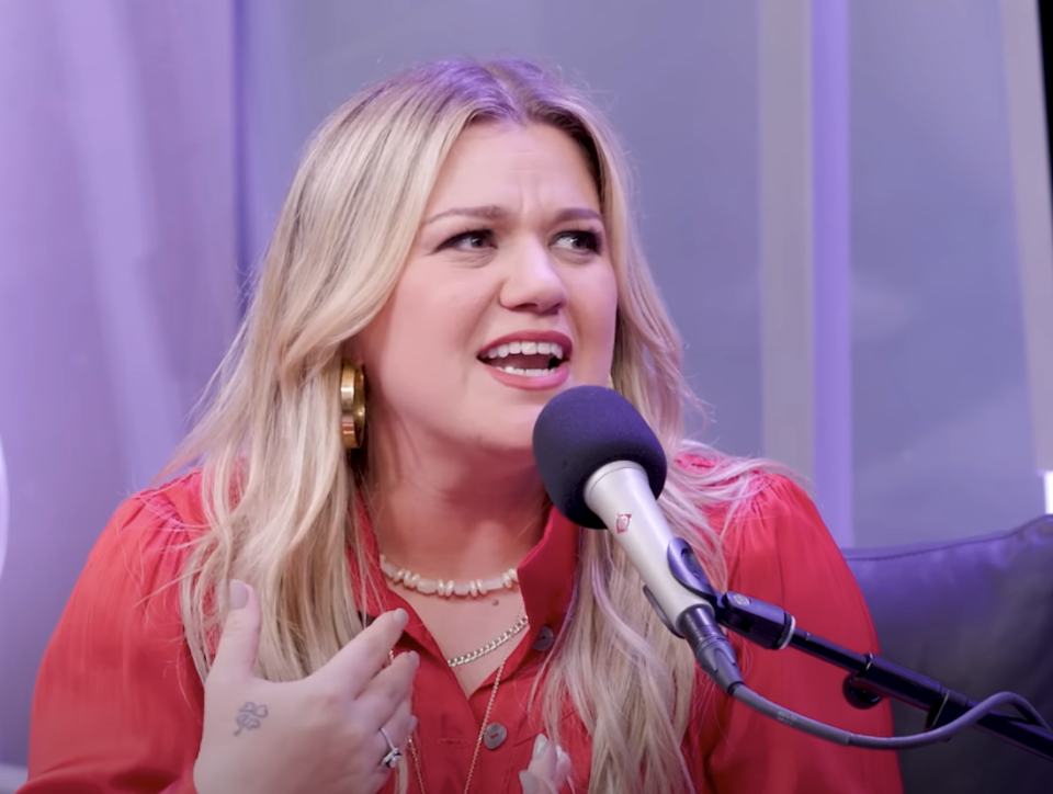 Close-up of Kelly sitting at a microphone