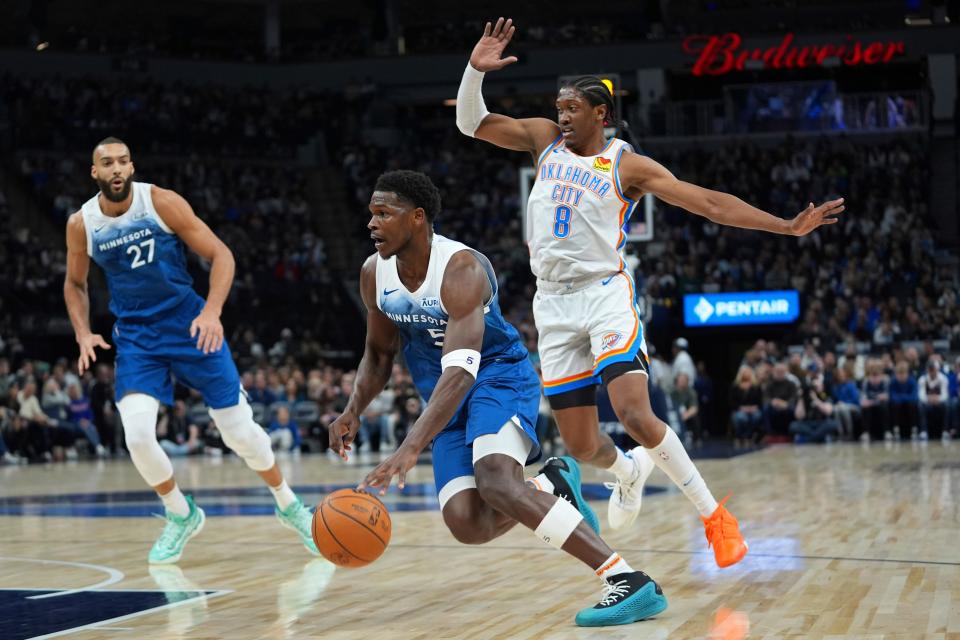 Minnesota Timberwolves guard Anthony Edwards, center, works toward the basket after getting past Oklahoma City Thunder forward Jalen Williams (8) during the first half of an NBA basketball game, Saturday, Jan. 20, 2024, in Minneapolis. (AP Photo/Abbie Parr)