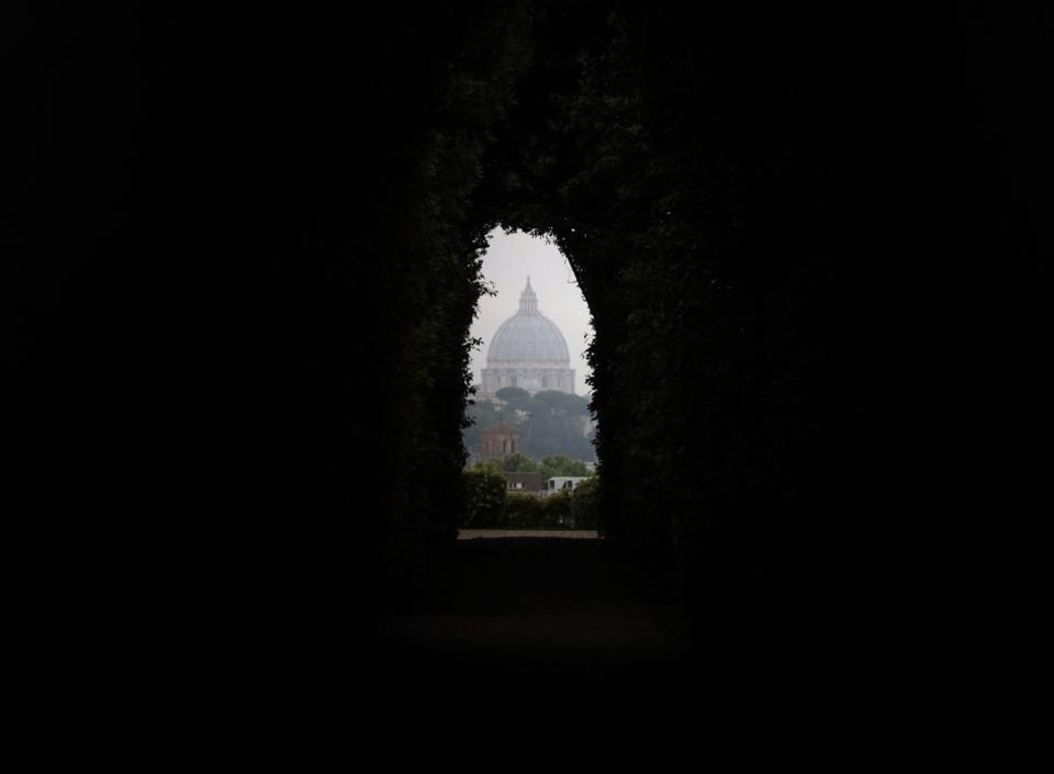 FILE - This May 28, 2012 file photo shows St. Peter's Basilica dome as seen through the spy hole of the Order of the Knights of Malta gardens in Rome. The villa owned by the Knights of Malta atop the ancient Aventine Hill, at No. 3 on the Piazza dei Cavalieri di Malta, has a large entry door with a celebrated keyhole. If you peer through it, you’ll have a perfectly framed view of the dome of St. Peter’s Basilica. (AP Photo/Gregorio Borgia, file)